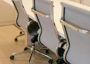 Modern office chairs in a conference room setting, featuring sleek design and metallic accents.