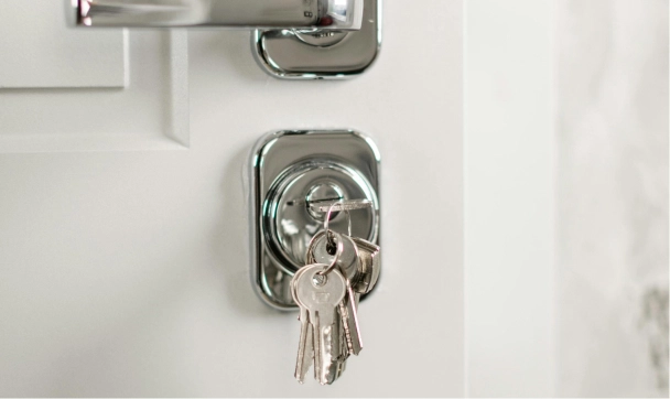 Keys hanging in a modern door lock, symbolizing security and access control for home entry.
