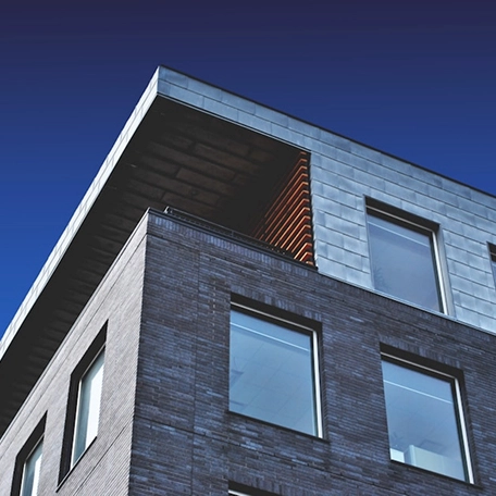 Modern building with large windows and sleek design against a clear blue sky.