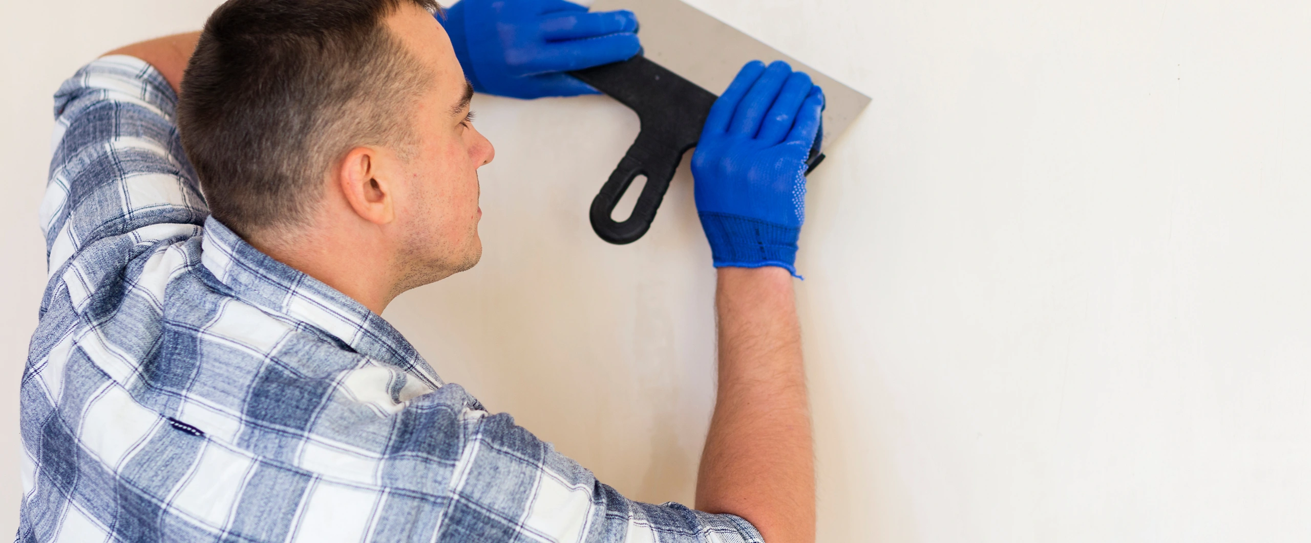 Professional contractor repairing drywall surface in a Bellevue, WA home