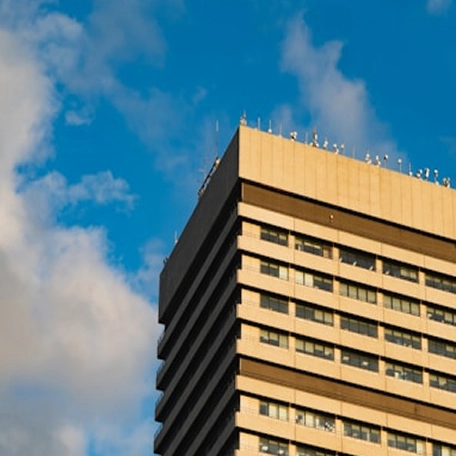 Close-up view of a modern building with a flat roof and multiple horizontal windows against a