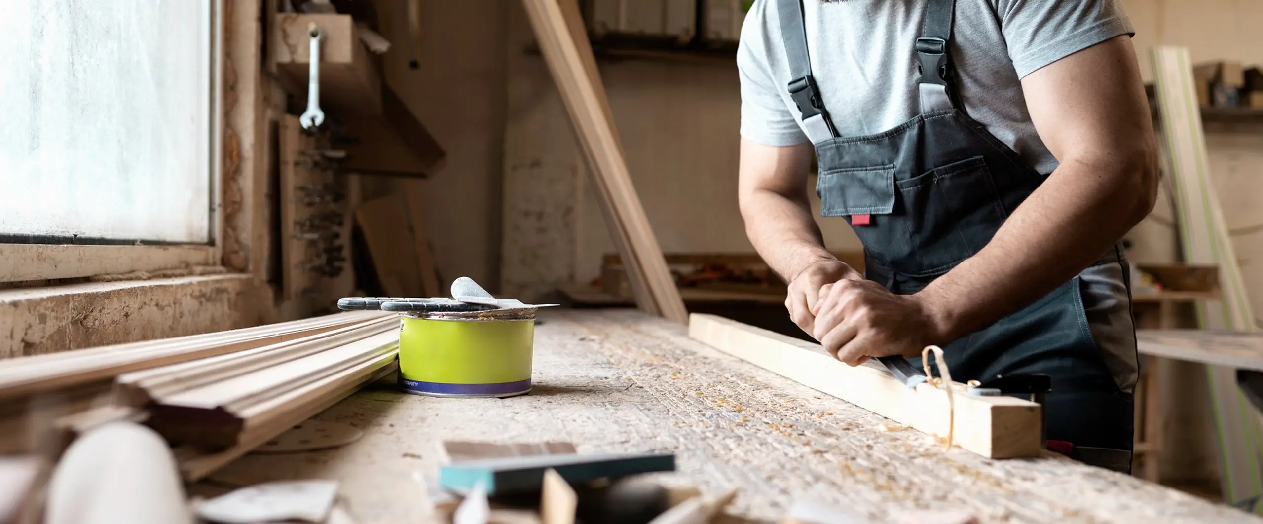 Carpenter smoothing wood with a hand planer for a commercial renovation